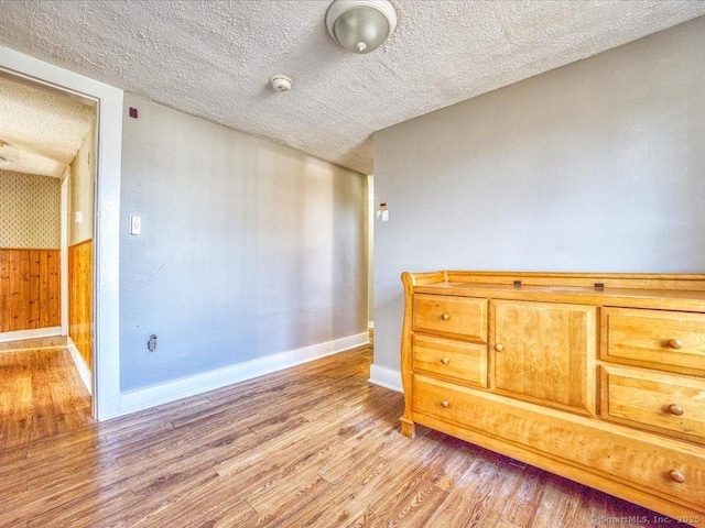 spare room featuring a textured ceiling and light hardwood / wood-style flooring