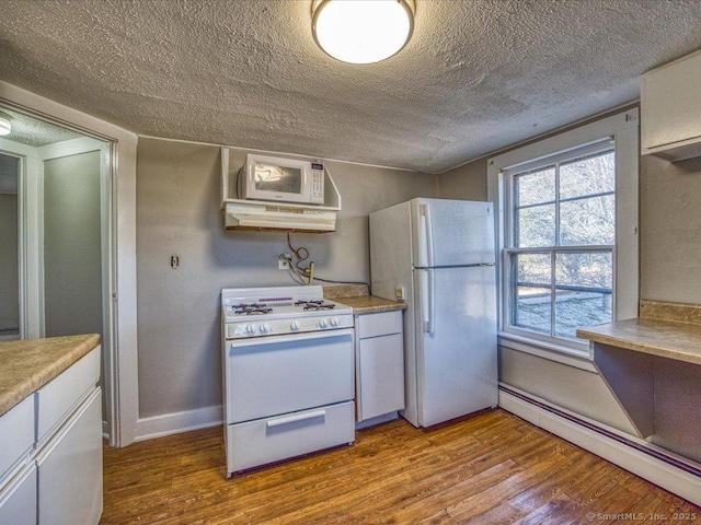 kitchen with white appliances, light wood-type flooring, a textured ceiling, and baseboard heating