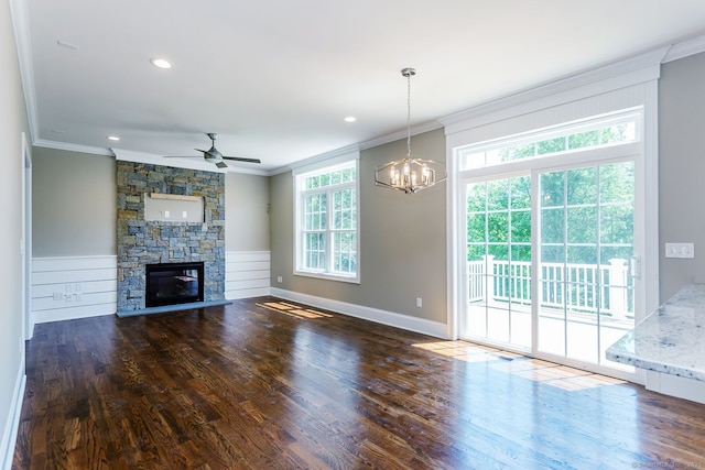 unfurnished living room featuring dark hardwood / wood-style floors, crown molding, a healthy amount of sunlight, and a fireplace