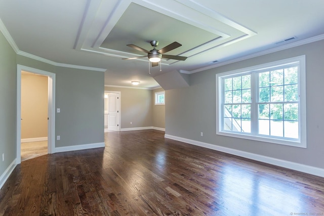 empty room featuring visible vents, dark wood finished floors, and ornamental molding