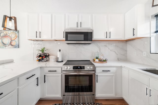 kitchen featuring pendant lighting, stainless steel appliances, light stone counters, tasteful backsplash, and white cabinets