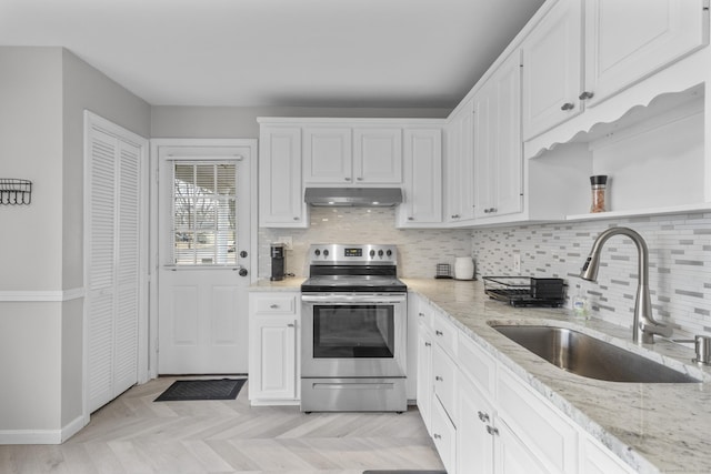 kitchen featuring sink, white cabinets, light stone counters, and stainless steel electric range