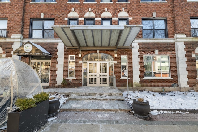 snow covered property entrance with french doors