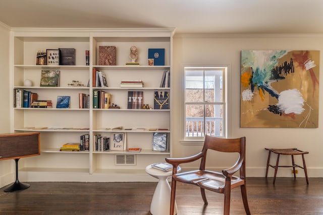 sitting room with dark wood-type flooring and crown molding