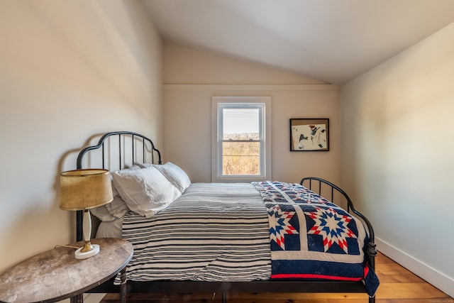 bedroom featuring hardwood / wood-style flooring and vaulted ceiling