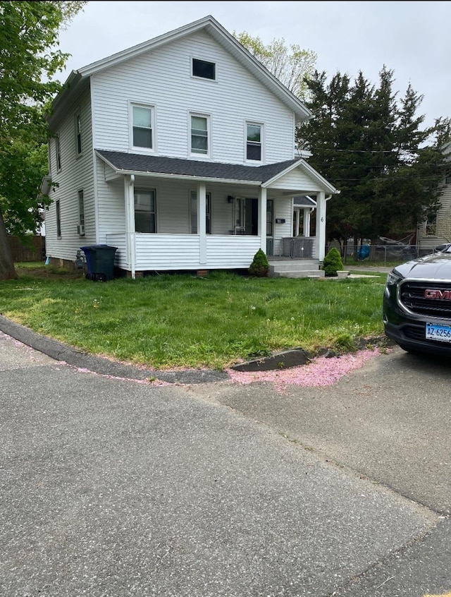 view of front of home with a front yard and covered porch