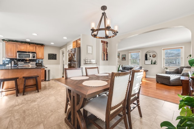 tiled dining room with an inviting chandelier