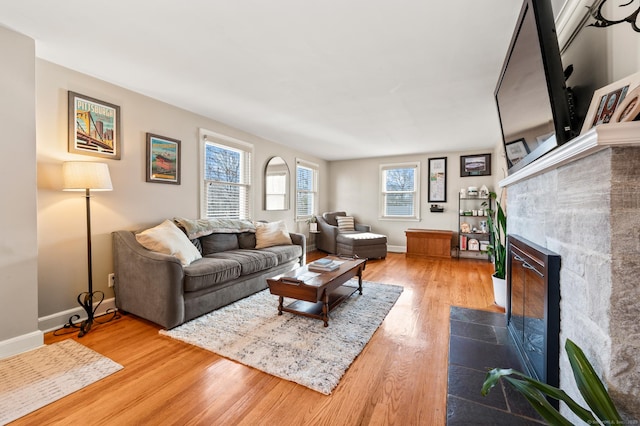 living room featuring a tile fireplace and hardwood / wood-style floors