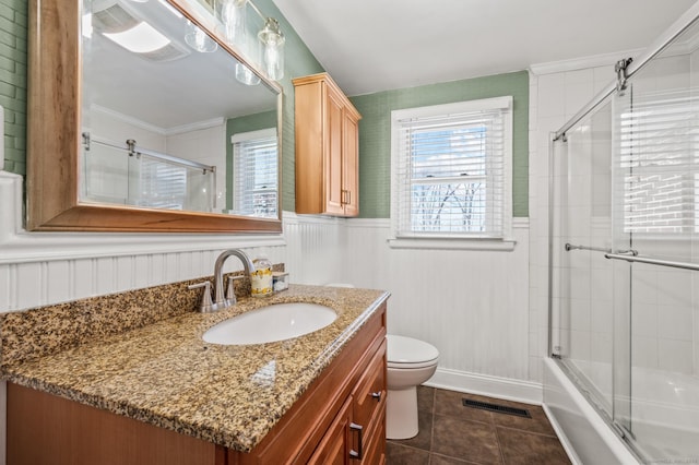 full bathroom with vanity, tile patterned floors, shower / bath combination with glass door, and toilet