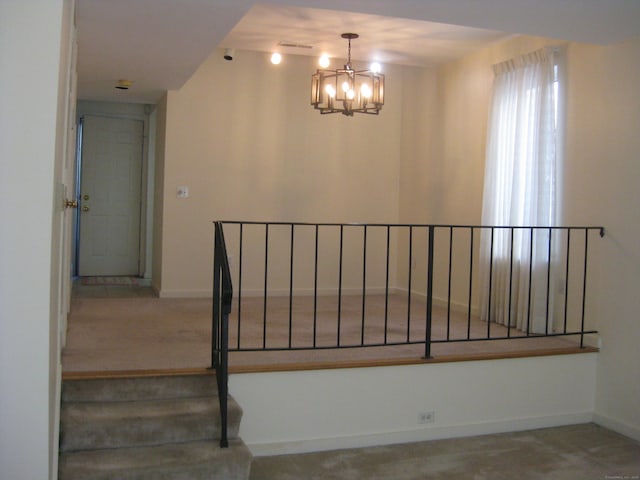 stairway featuring a chandelier