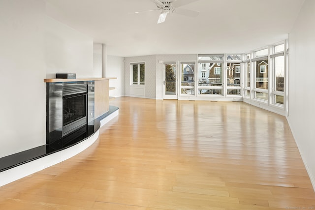 unfurnished living room featuring ceiling fan and light wood-type flooring