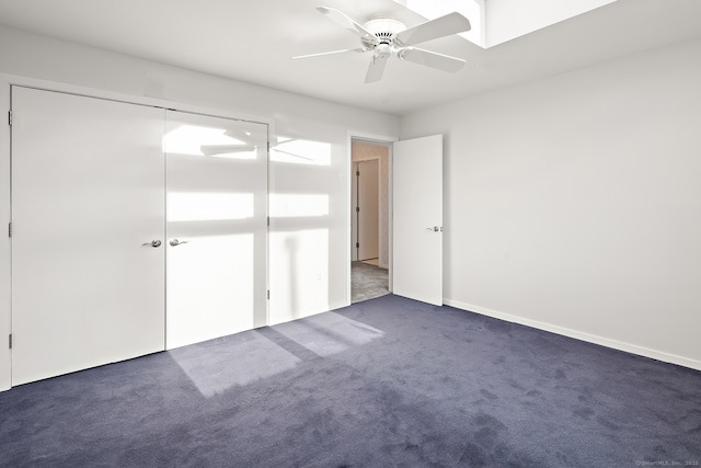 unfurnished bedroom featuring a closet, ceiling fan, and dark colored carpet