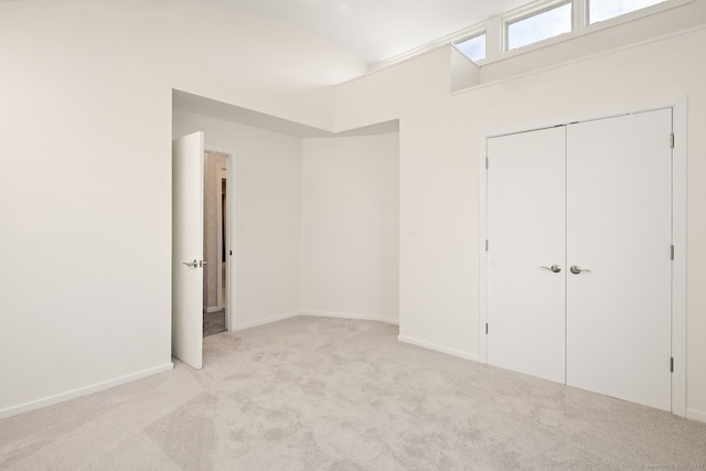 unfurnished bedroom with light colored carpet and a closet