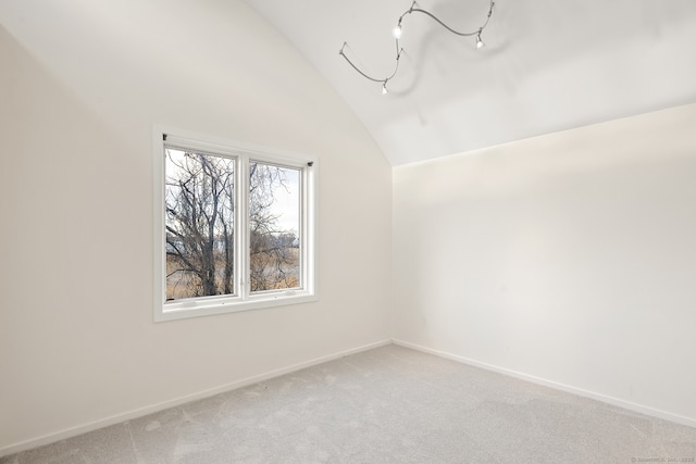 carpeted empty room featuring lofted ceiling