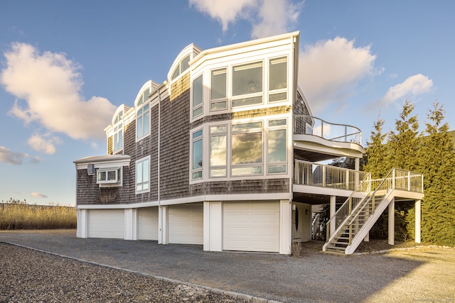 back of property featuring a wooden deck and a garage