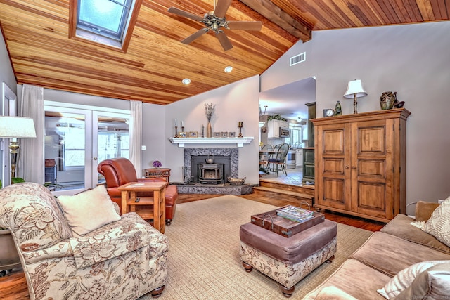 living room with wood ceiling, ceiling fan, vaulted ceiling with skylight, wood-type flooring, and french doors