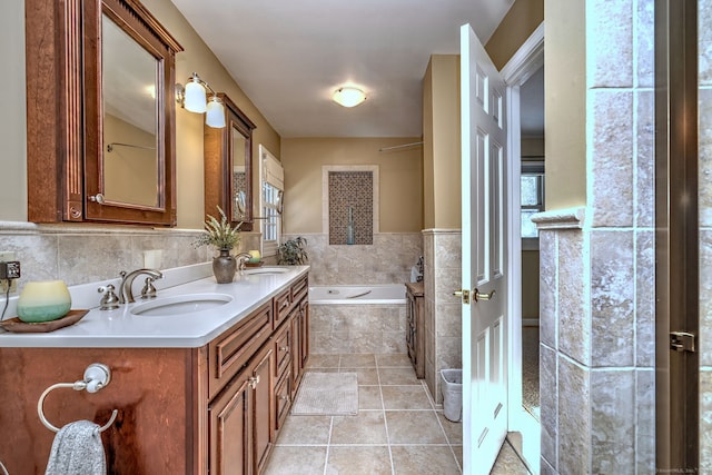 bathroom with vanity, tile patterned flooring, and tiled tub