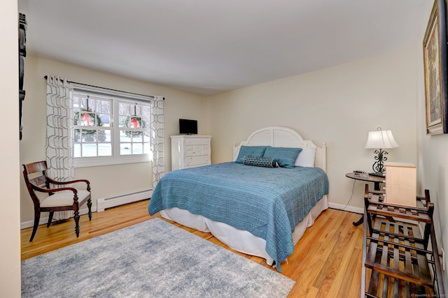 bedroom with a baseboard radiator and wood-type flooring