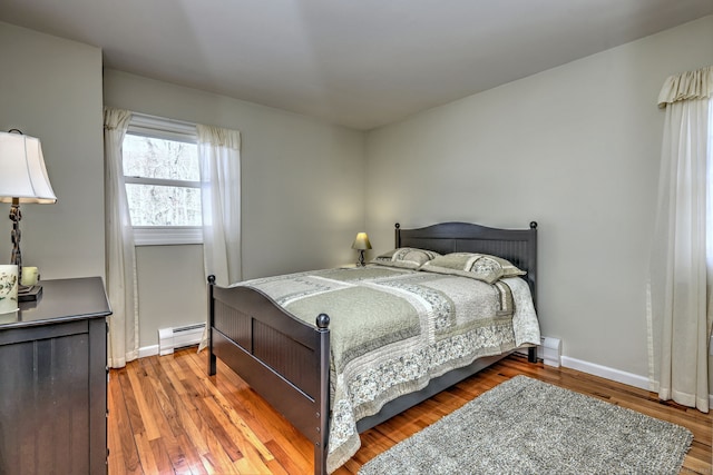 bedroom featuring hardwood / wood-style flooring and a baseboard radiator