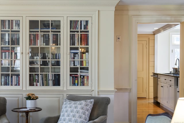 living area featuring light wood-type flooring and crown molding