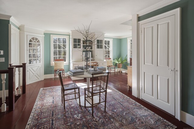 dining space with baseboards, hardwood / wood-style flooring, and crown molding