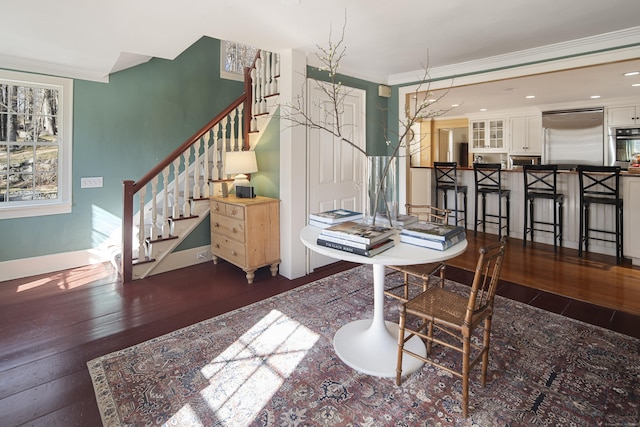 dining area with hardwood / wood-style flooring, baseboards, stairway, and ornamental molding