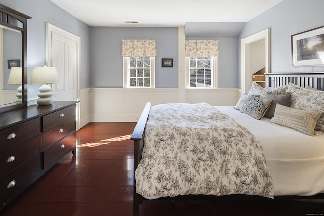 bedroom with dark wood-style floors, baseboards, visible vents, and vaulted ceiling