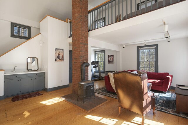 living room featuring light wood-style floors, a wealth of natural light, and a towering ceiling