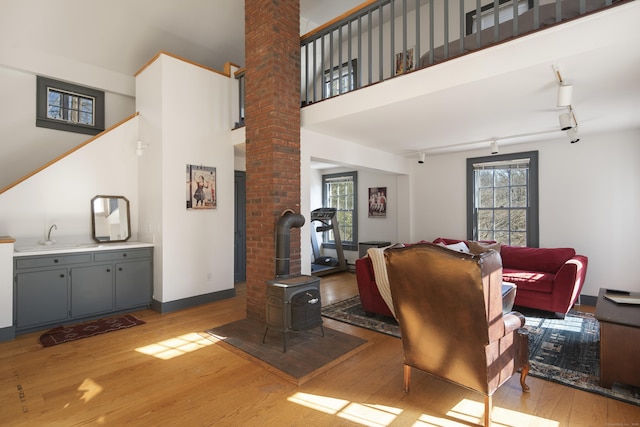 247 Mill Rd, New Canaan, CT 06840 - living area with ornate columns, light wood-type flooring, a wood stove, and baseboards