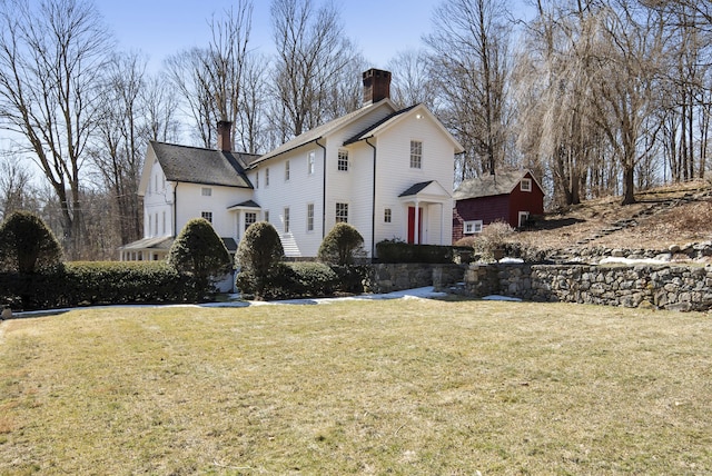 view of front of property featuring a chimney and a front lawn