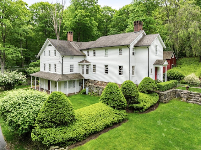 247 Mill Rd, New Canaan, CT 06840 - rear view of property featuring a chimney, a shingled roof, and a lawn