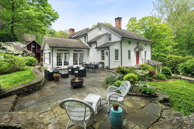 247 Mill Rd, New Canaan, CT 06840 - rear view of house with french doors, an outdoor living space with a fire pit, and a patio area
