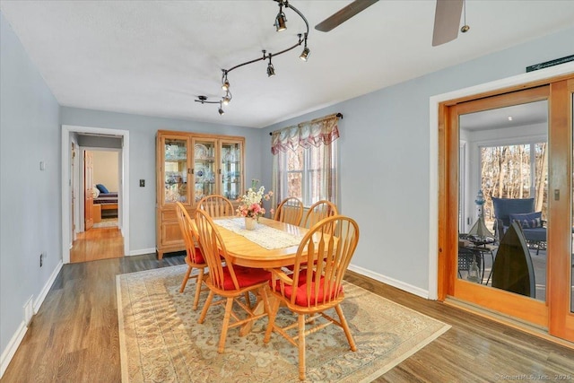 dining room featuring rail lighting, hardwood / wood-style floors, and ceiling fan