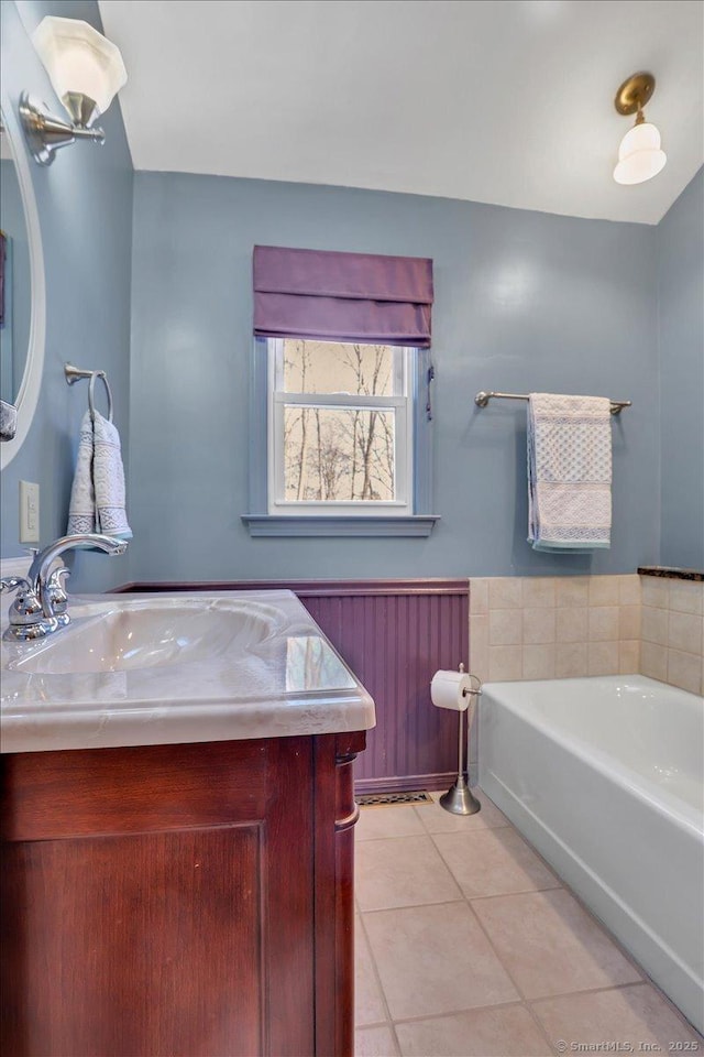 bathroom featuring tile patterned floors, a tub to relax in, vanity, and radiator heating unit