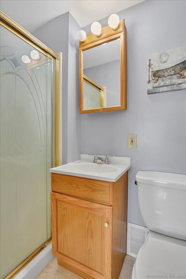 bathroom featuring vanity, tile patterned flooring, toilet, and walk in shower