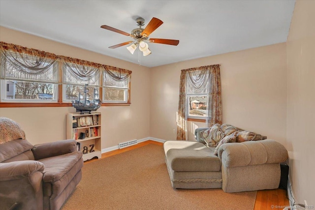 living area featuring hardwood / wood-style flooring and ceiling fan