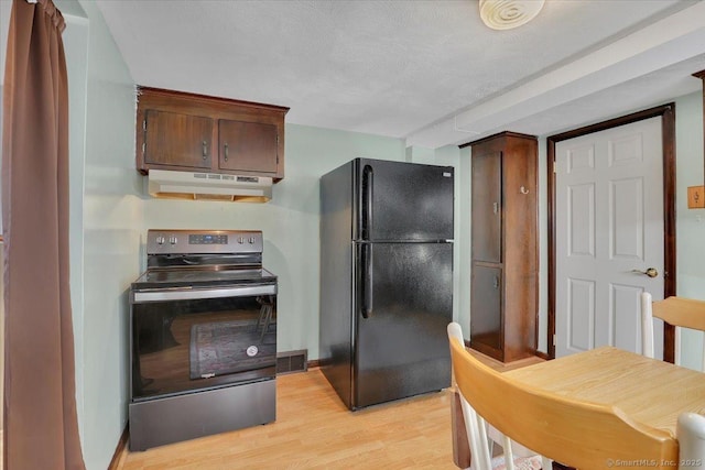 kitchen featuring black refrigerator, a textured ceiling, stainless steel electric range, and light hardwood / wood-style flooring