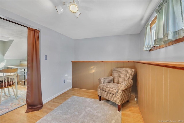 living area featuring light hardwood / wood-style floors and wood walls