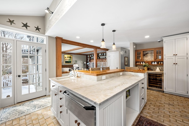 kitchen with beverage cooler, decorative light fixtures, a sink, and recessed lighting