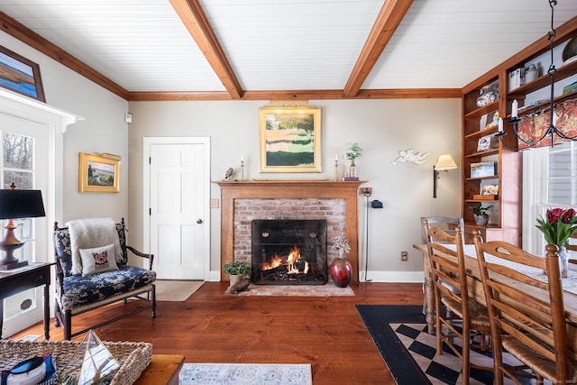 interior space with hardwood / wood-style floors, a fireplace, baseboards, and beam ceiling