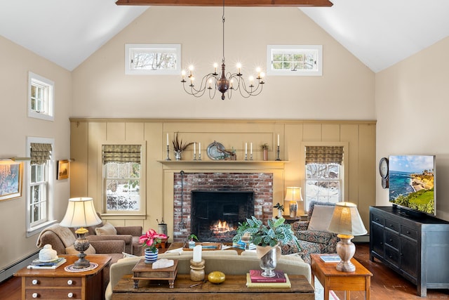 living area featuring high vaulted ceiling, a fireplace, wood finished floors, and an inviting chandelier