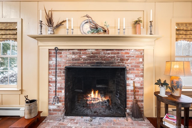 interior details with a brick fireplace and a baseboard radiator