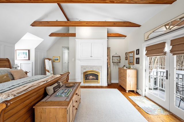 bedroom featuring vaulted ceiling with beams, access to outside, light wood finished floors, and a baseboard radiator