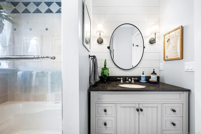 full bath featuring a tub, walk in shower, and vanity