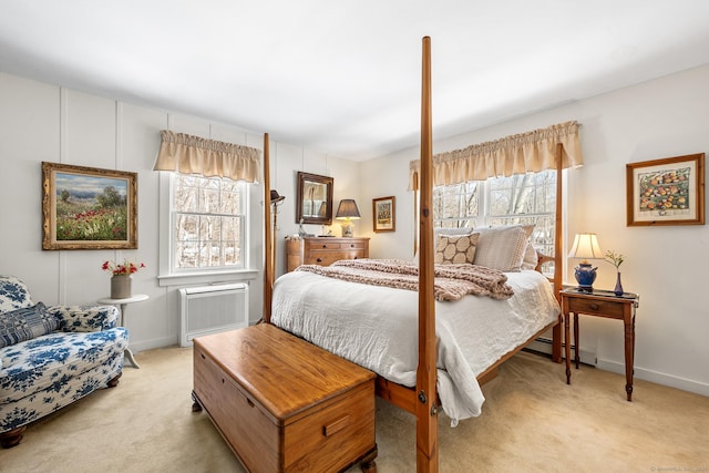 bedroom with light carpet, a baseboard heating unit, multiple windows, and baseboards