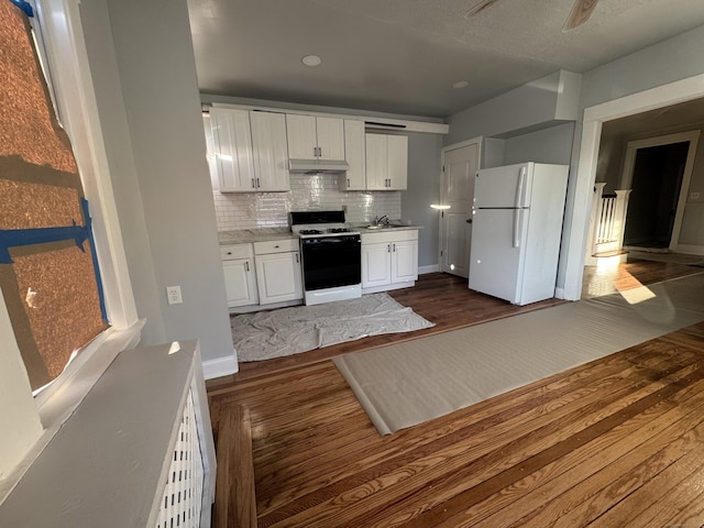 kitchen featuring white cabinetry, tasteful backsplash, white refrigerator, dark hardwood / wood-style floors, and range with gas stovetop