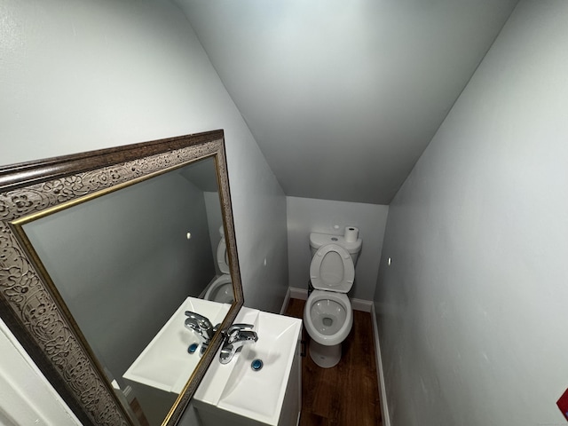 bathroom featuring lofted ceiling, hardwood / wood-style floors, and toilet