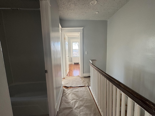 hall featuring a textured ceiling