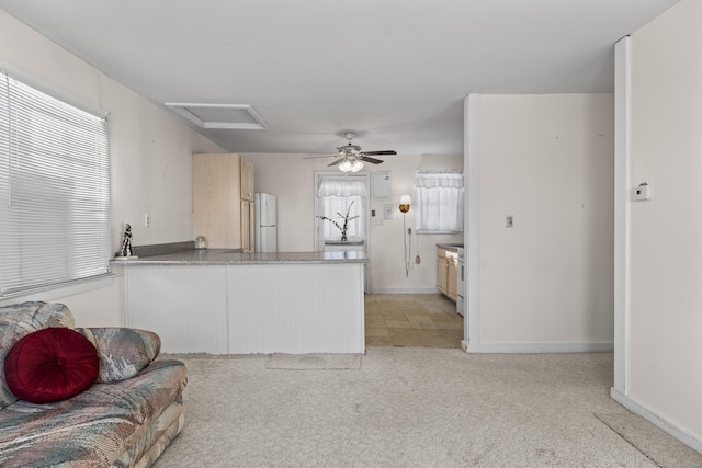 kitchen with light colored carpet, kitchen peninsula, ceiling fan, and white refrigerator