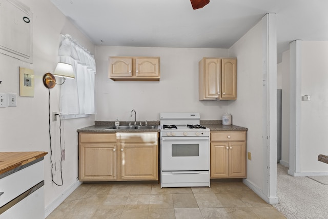 kitchen featuring light tile patterned floors, sink, white gas stove, and light brown cabinets